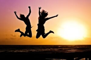 new year background, sunset, nature, beach, silhouettes, jump, jumping, youth, active, happy, pair, girls, young women, people, joy, freedom, seaside, dusk